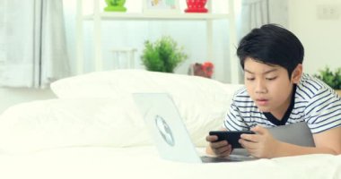 Smartphone ve daktilo ile gülümsemek yüz holding sevimli Asya çocuk eller.