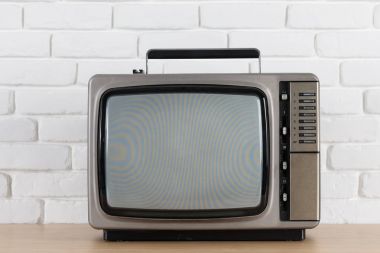 Beyaz tuğla duvar arka plan üzerinde eski televizyon.
