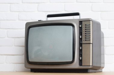Beyaz tuğla duvar arka plan üzerinde eski televizyon.