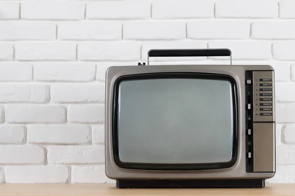 Oude TV op een witte bakstenen muur achtergrond. — Stockfoto