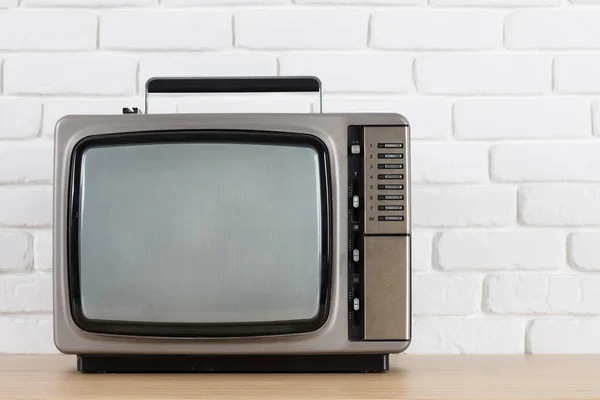Stary telewizor na tle ściany Cegła biała. — Zdjęcie stockowe