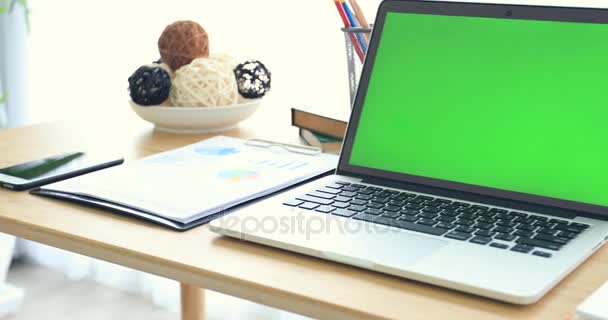 緑色の画面で机の上のノート パソコン. — ストック動画