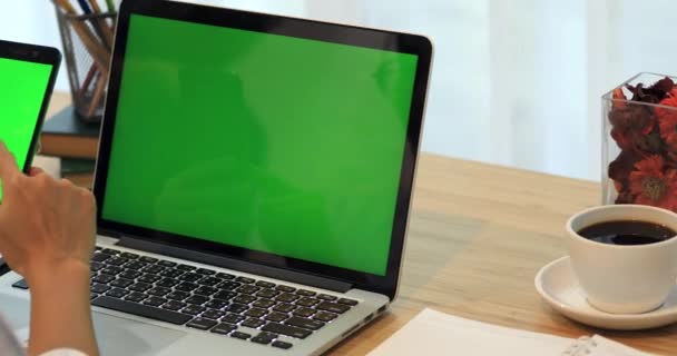 Aziatische vrouw hand met mobiele telefoon. Telefoon en Laptop op Bureau met groen scherm. — Stockvideo