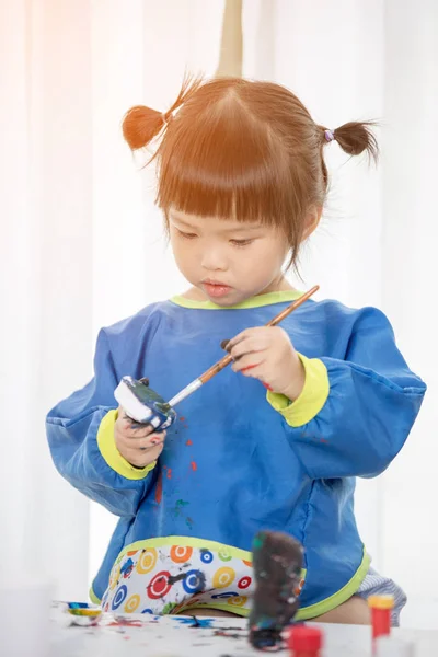 Портрет милої маленької дівчинки, що весело грає з фарбами . — стокове фото