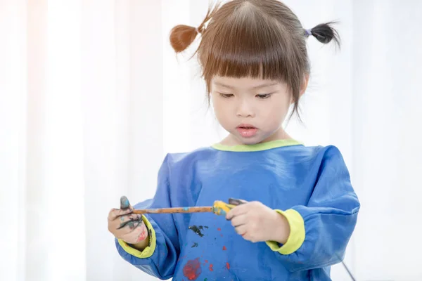 Retrato de uma menina bonita brincando messily com tintas . — Fotografia de Stock