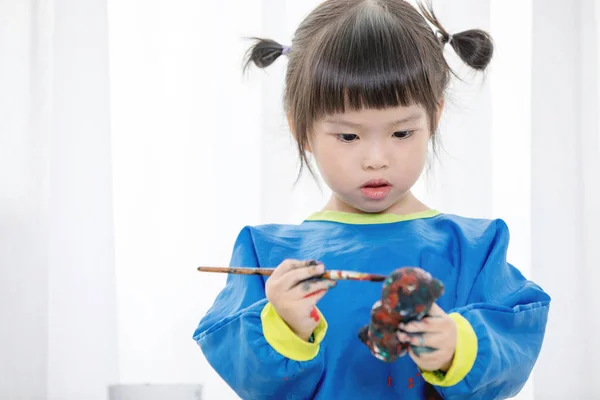 Portret van een schattig klein meisje Desinformatieraketten spelen met verf. — Stockfoto