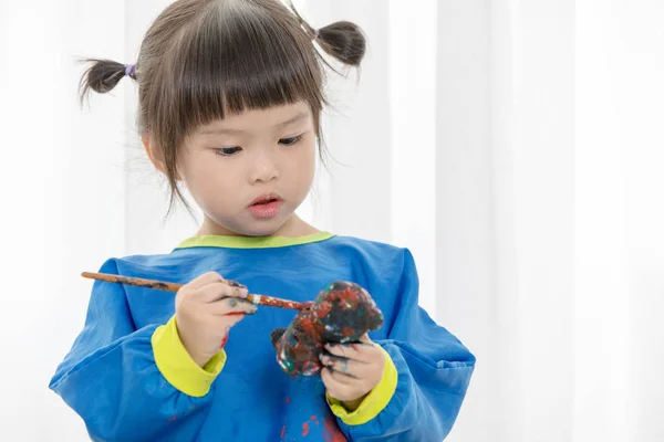 Retrato de uma menina bonita brincando messily com tintas . — Fotografia de Stock