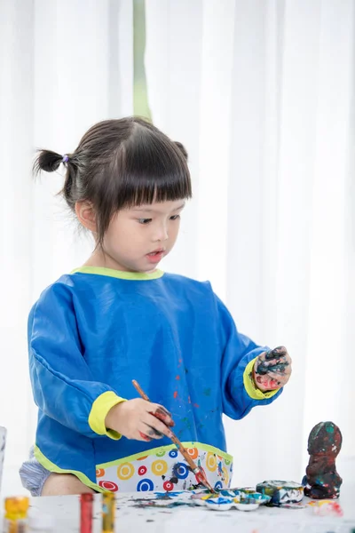 Retrato de uma menina bonita brincando messily com tintas . — Fotografia de Stock