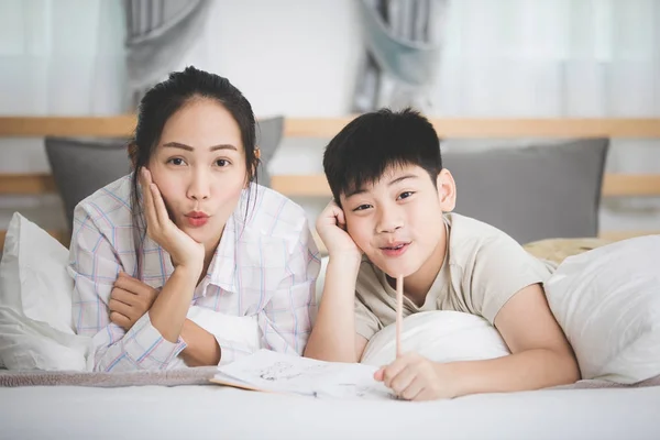 Feliz irmão asiático e irmã descansar na cama e escrever . — Fotografia de Stock