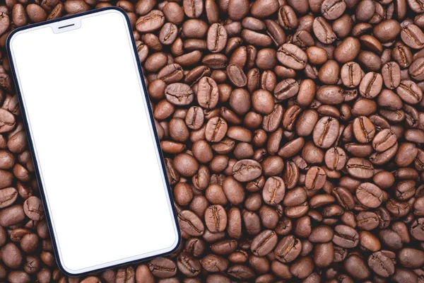 Wit mobiele telefoon van de cel met leeg scherm op gebrande koffie — Stockfoto