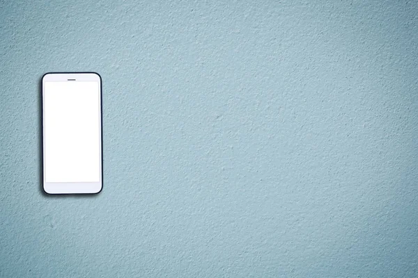 Téléphone portable blanc avec écran blanc sur mur en béton bleu — Photo