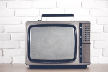 Beyaz tuğla duvar arka plan üzerinde eski televizyon.