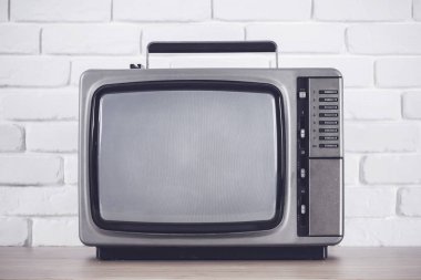 Beyaz tuğla duvar arka plan üzerinde eski televizyon.