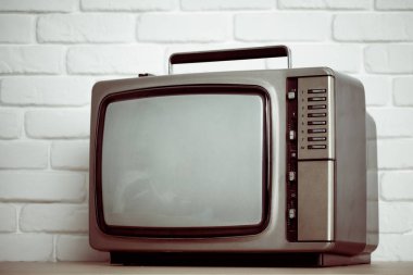Beyaz tuğla duvar arka plan üzerinde eski televizyon.
