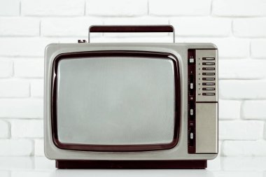 Beyaz tuğla duvar arka plan üzerinde eski televizyon.