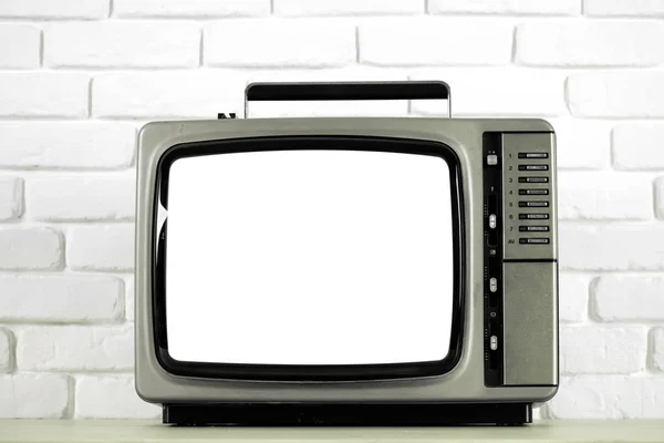 Old television with cut out screen on a white brick wall — Stock Photo, Image