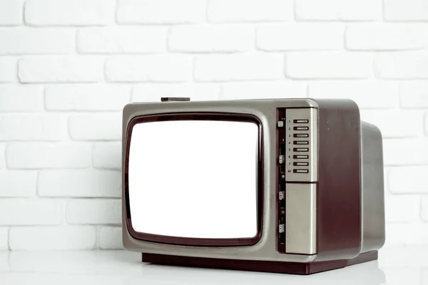 Old television with cut out screen on a white brick wall — Stock Photo, Image