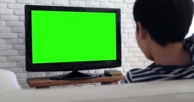 Asyalı çocuk oyun bilgisayar oyunu kullanarak yeşil ekran ile Arkadan Görünüm televizyon.