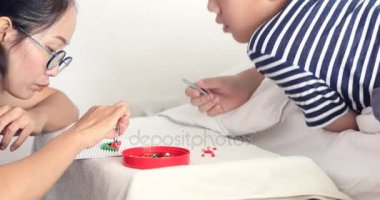 Asyalı kız kardeşi pratiği ve genç kardeşi ile oynamaktan evde yüzünü gülümseme .