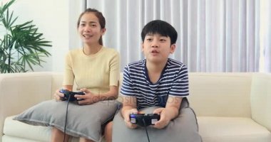 Mutlu Asya aile evde gülümsemek yüz ile oyun oynamak. Taylandlı kız ve erkek kardeş birlikte oyun oynarken .