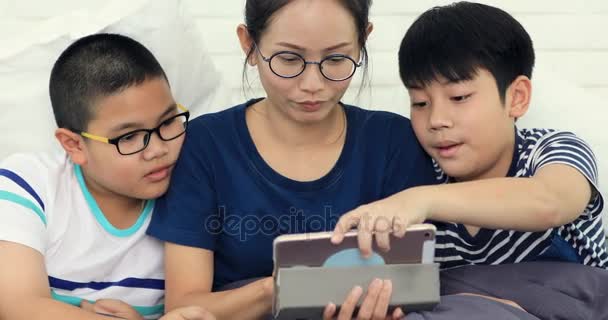 愉快的亚洲家庭的姐妹和兄弟与朋友玩平板电脑在家里面带微笑的脸 — 图库视频影像