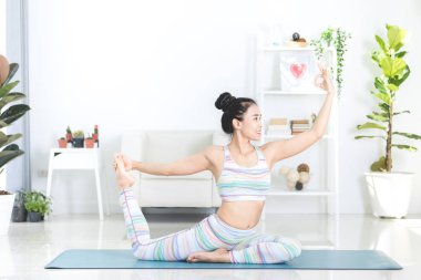 Asyalı güzel spor kadın egzersizleri evde gerçekleştirir .