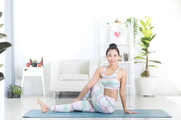 Asian beautiful sports woman performs the exercises at home . — Stock Photo, Image