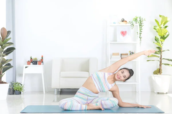 Asiática hermosa mujer de los deportes realiza los ejercicios en casa  . — Foto de Stock