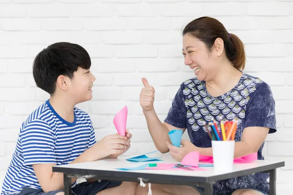 Menino asiático com mãe ensinando e aprendendo sua lição de casa em casa — Fotografia de Stock