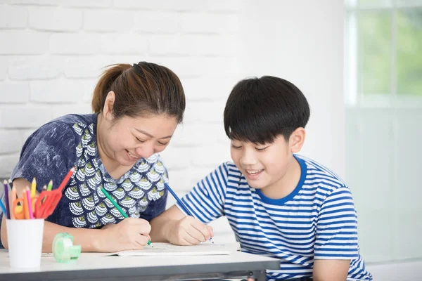 Ázsiai fiú, a tanítás és a tanulás a házit otthon anya — Stock Fotó