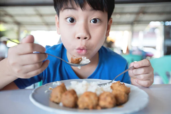 亚洲逗人喜爱的男孩吃早餐和看照相机与微笑面孔 — 图库照片