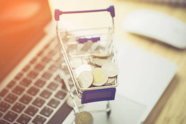 Shopping cart with coin on a laptop keyboard. — Stock Photo, Image