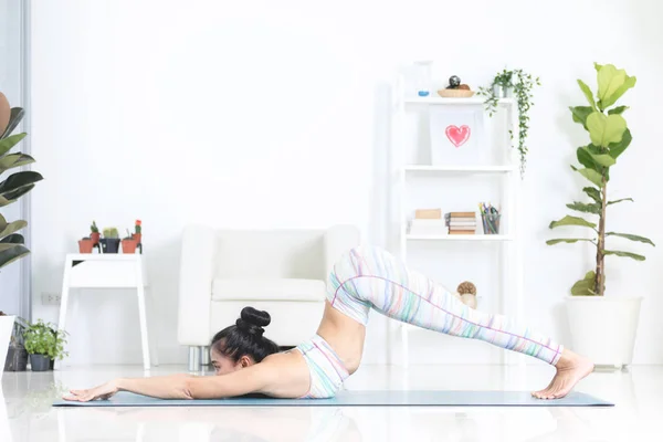 Asiática hermosa mujer de los deportes realiza los ejercicios en casa  . — Foto de Stock