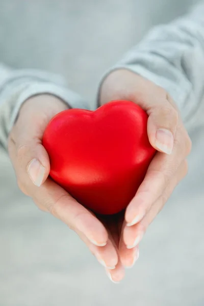 Женские руки, дающие красное сердце — стоковое фото