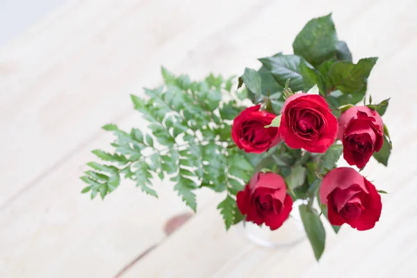 Red rose on wood background with copy space.