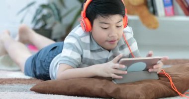 Katta ve gülümsemek yüz evde oynarken tablet bilgisayarınızla Asya öncesi gençler dinlenme.