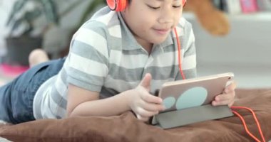 Asya öncesi gençler katta ve gülümsemek yüz evde oynarken tablet bilgisayarınızla dinlenmek yakın çekim.