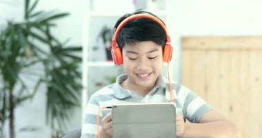 Asya öncesi gençler gülümsemek yüz evde tablet bilgisayarınızla oynamaya yakın çekim.