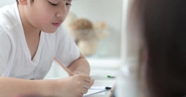 Kalem tutan ve ödevini evde yazma mutlu Asya sevimli çocuk el.