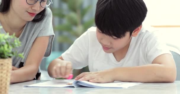 Aziatische Moeder Helpt Haar Zoon Huiswerk Van School Thuis Doen — Stockvideo