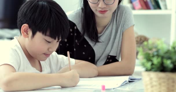 Aziatische Moeder Helpt Haar Zoon Huiswerk Van School Thuis Doen — Stockvideo