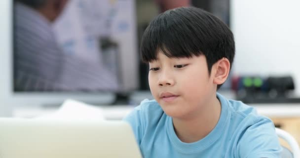 Χαριτωμένο Ασίας Αγόρι Που Χρησιμοποιούν Φορητό Υπολογιστή Στο Σπίτι — Αρχείο Βίντεο