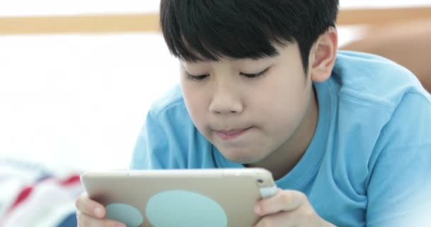 Leuke Aziatische Jongen Horloge Spelen Tablet Met Stil Gezicht — Stockvideo