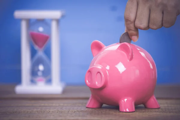 Invoegen van een munt in een piggy bank — Stockfoto