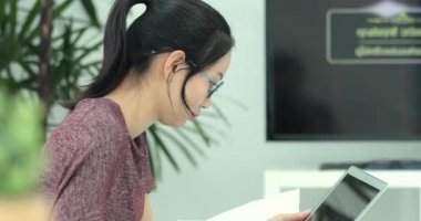 Asyalı kadın yatakta web taramak için onu laptop kullanıyor