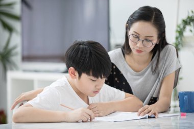 Öğretme ve öğrenme ödevini evde annesi ile Asya çocuk