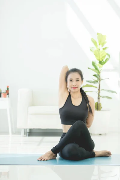 Beautiful asian sports woman performs the exercises at home .Yog