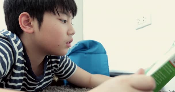 Asiatische Pre Teen Rest Auf Dem Boden Und Lesen Cartoons — Stockvideo