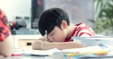 Oturma odasında ödev oğlu ile ciddi Asya anne. Anne oğlu öğretir nasıl yapılır dahi.