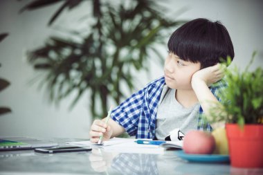 Asya şirin küçük çocuk ciddi bir yüz ile kitap okuma .